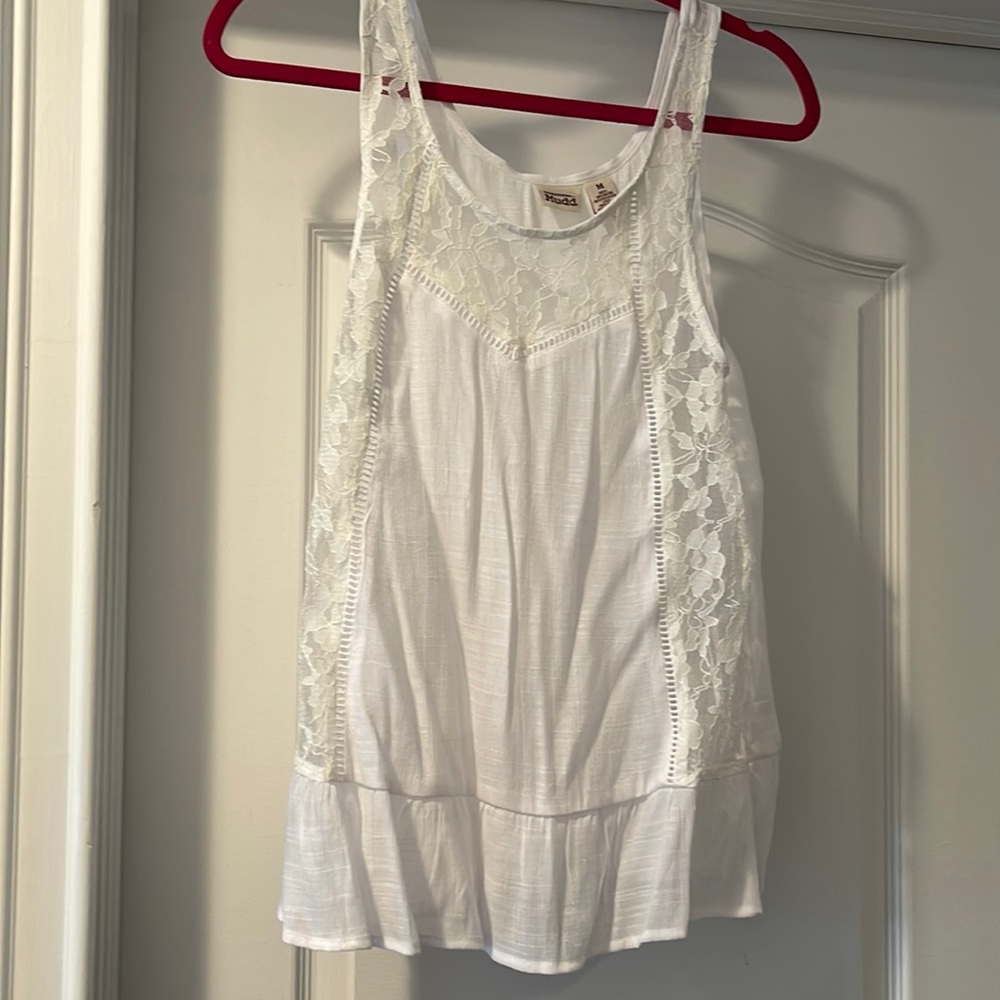 Gauzy white tank with ruffle bottom and lace sides.  Mostly sheer. Never worn